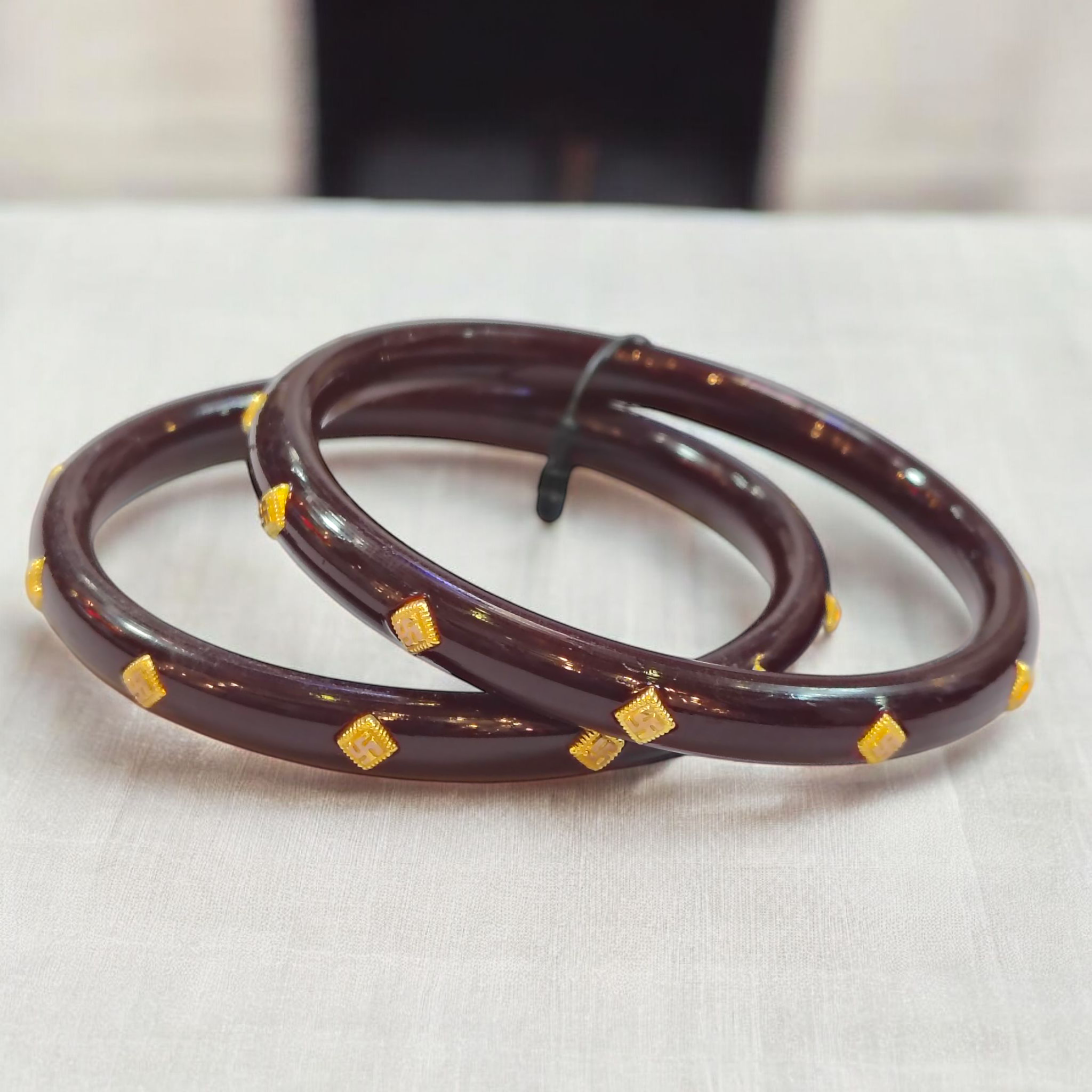 (GPPB) COFFEE SWASTIK MEDIUM LOCAL (50 TONCH) KDM GOLD PASTING POLA BADHANO 1 PAIR FOR REGULAR USE APPROX WGT: 0.400 GM (NOTE: DEDUCTION OF WGT: 0.100 GM WHEN EXCHANGED WITH ANY JEWELLERY FOR LIFETIME)