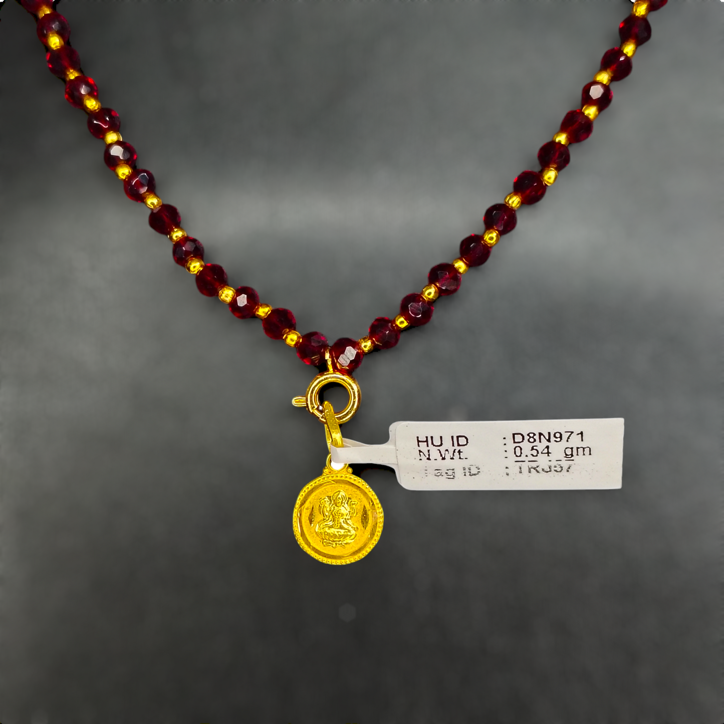 TRJ WGT: 0.540 GM APPROX 22KT HUID HALLMARK GOLD LOCKET 1 PIECE WITH ADJUSTABLE TASSEL.